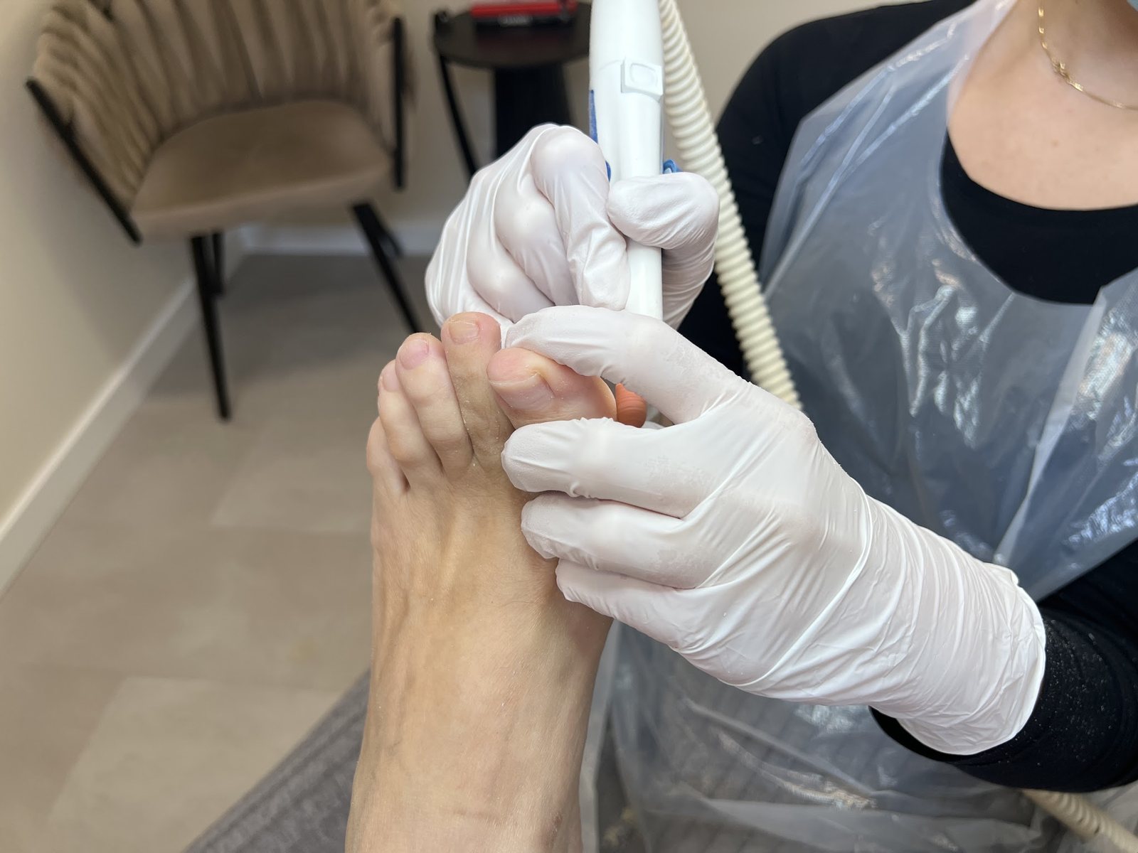 Pedicure behandeling: met handschoenen aan worden de teennagels van een klant verzorgd